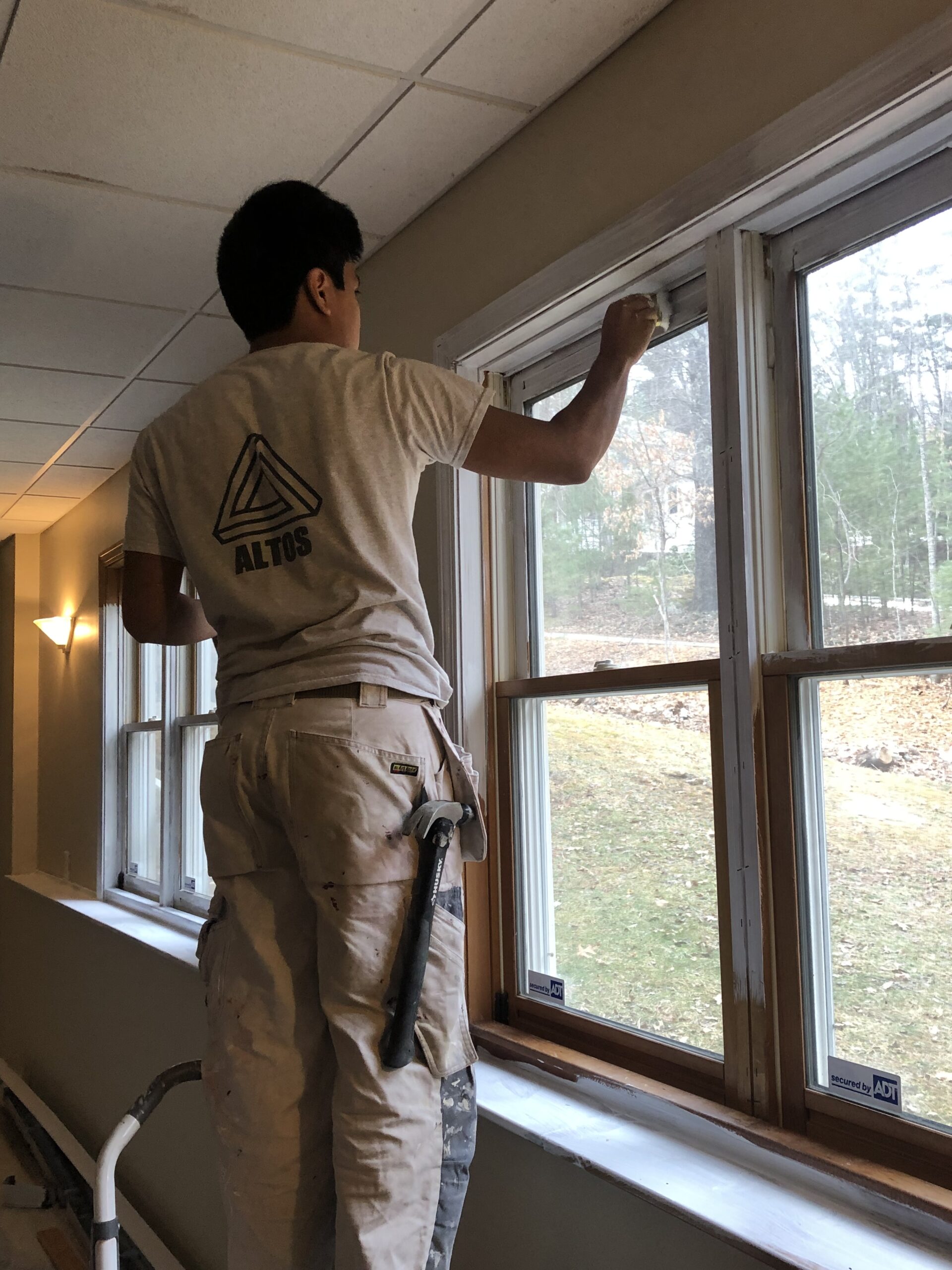 josh painting window trim with white paint